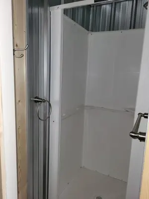 a shower in a bathroom with a glass door at THE ORCHARD (HOSTEL WITH PRIVATE BUNKS) in Radium Hot Springs