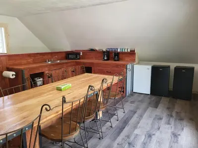 a room with a table and chairs and a kitchen at THE ORCHARD (HOSTEL WITH PRIVATE BUNKS) in Radium Hot Springs