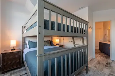 a bedroom with a bunk bed with a ladder at Fully Renovated Ski-in/out Loft with Private Hot Tub! in Golden