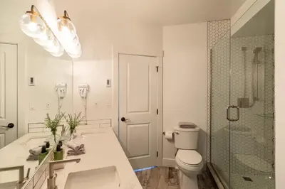 a white bathroom with a toilet and a shower at Fully Renovated Ski-in/out Loft with Private Hot Tub! in Golden
