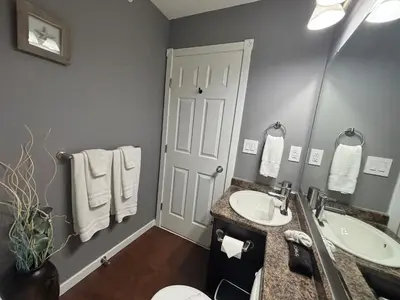 a bathroom with a sink and a toilet and a mirror at Top Floor Riverfront Condo with Stellar Sunsets! in Fort McMurray