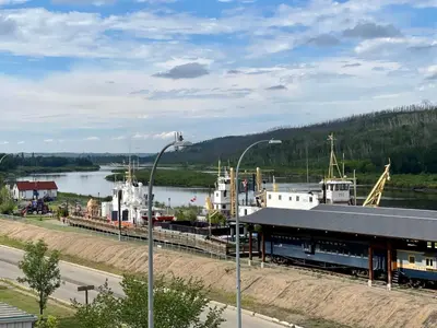 a train station next to a body of water at Top Floor Riverfront Condo with Stellar Sunsets! in Fort McMurray