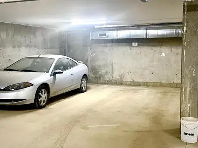 a white car parked in a parking garage at Top Floor Riverfront Condo with Stellar Sunsets! in Fort McMurray