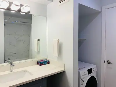 a bathroom with a sink and a washing machine at A Romantic Studio with Full Kitchen & AC-141 in Canmore