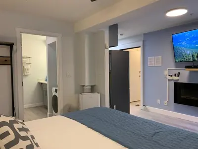 a bedroom with a bed and a tv on a wall at A Romantic Studio with Full Kitchen & AC-141 in Canmore