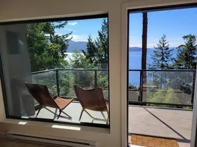 two chairs sitting on the balcony of a house at J and Js in Bowen Island