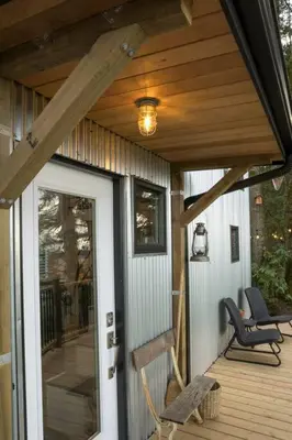 a porch of a house with a door and chairs at Tiny House Big View in Chilliwack