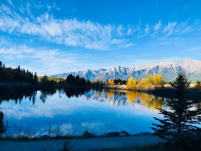 a view of a lake with mountains in the background at Romantic 1-Bedroom Serviced Apartment Kitchen & AC 143 in Canmore