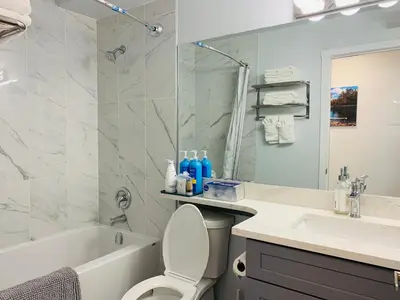 a bathroom with a tub and a toilet and a sink at Romantic 1-Bedroom Serviced Apartment Kitchen & AC 143 in Canmore