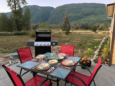 a table with chairs and a grill on a patio at Country home, Sleeps 6 pets friendly in Port Alberni