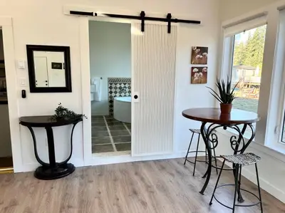 a room with two tables and a door with a tub at Country home, Sleeps 6 pets friendly in Port Alberni
