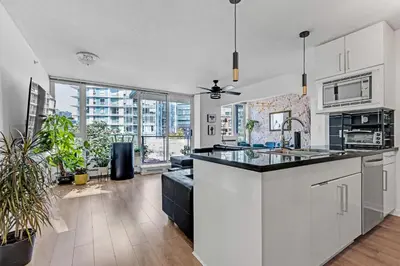 a kitchen with white cabinets and a large window at Gastown Downtown Apartment very central in Vancouver