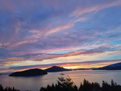 a sunset over a large body of water at Vancouver sea view Palace inn in West Vancouver
