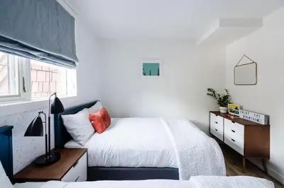 a bedroom with two beds and a desk with a lamp at Mount Rundle Hideaway - Pool Hot Tub in Canmore