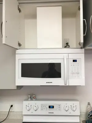 a microwave above a stove in a kitchen at The Purple Door Carriage House in Lantzville