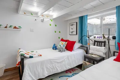 a bedroom with two beds and a window at Triceratops Landing I Fire Place I Games I Netflix in Drumheller