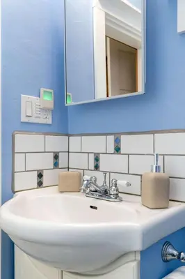 a bathroom with a white sink and a mirror at Triceratops Landing I Fire Place I Games I Netflix in Drumheller