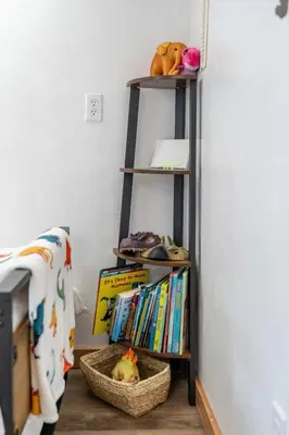a book shelf with books and a basket of books at Triceratops Landing I Fire Place I Games I Netflix in Drumheller