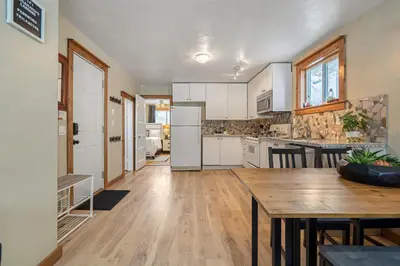 a kitchen with a table and a dining room at Triceratops Landing I Fire Place I Games I Netflix in Drumheller