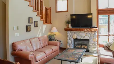 a living room with a couch and a fireplace at Woodhaven #18 by Bear Country in Sun Peaks