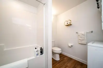 a white bathroom with a toilet and a shower at Exotic,LUSH,Rainforest,CR,Suite,King,U/G,Wifi in Edmonton