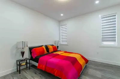 a bedroom with a bed with a colorful blanket at Charming, Cheerful, Exquisite 4 BR house, free wifi, free parking, free cancelation in Langley