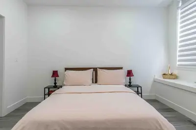 a white bedroom with a large bed with two lamps at Charming, Cheerful, Exquisite 4 BR house, free wifi, free parking, free cancelation in Langley