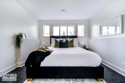 a bedroom with a large bed with white sheets and pillows at Stunning Modern Suite - King Bed - Free Parking & Netflix - Fast Wi-Fi - Long Stays Welcome in Edmonton