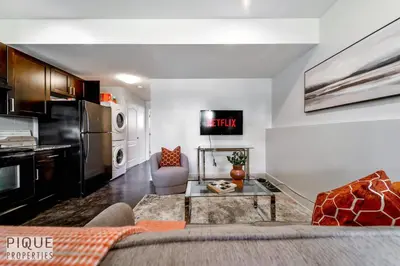 a living room with a couch and a table at Stunning Modern Suite - King Bed - Free Parking & Netflix - Fast Wi-Fi - Long Stays Welcome in Edmonton