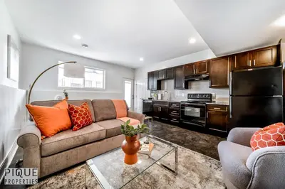 a living room with a couch and a kitchen at Stunning Modern Suite - King Bed - Free Parking & Netflix - Fast Wi-Fi - Long Stays Welcome in Edmonton