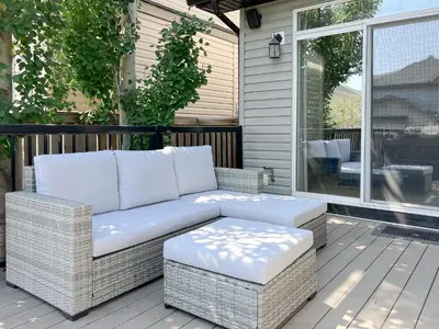 a wicker couch and ottoman on a patio at Serene and Secure Home Sweet Home with Office, 15 mins to Airport, 20 mins to Downtown, 90 mins to Banff in Calgary