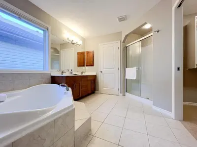a bathroom with a tub and a shower and a sink at Serene and Secure Home Sweet Home with Office, 15 mins to Airport, 20 mins to Downtown, 90 mins to Banff in Calgary