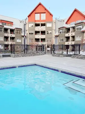 an empty swimming pool in front of apartment buildings at Ski-in/Ski-out Intentionally Designed Ski Lodge in Whistler