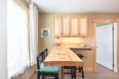 a dining room with a wooden table and chairs at Craftsman's Loft - Heritage charm - AC - 5 min DT in Calgary
