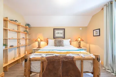 a bedroom with a large bed and two lamps at Craftsman's Loft - Heritage charm - AC - 5 min DT in Calgary