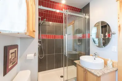 a bathroom with a shower and a sink at Craftsman's Loft - Heritage charm - AC - 5 min DT in Calgary