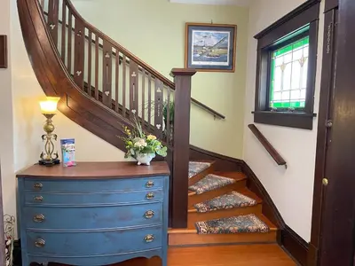 a staircase with a blue dresser and a blue chest of drawers at Fisher House Victoria Bed and Breakfast in Victoria