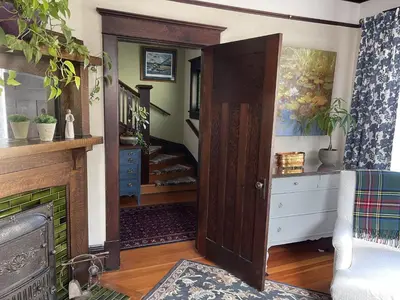 a living room with an open door and a staircase at Fisher House Victoria Bed and Breakfast in Victoria