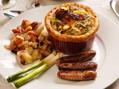 a white plate of food with sausage and a pie at Fisher House Victoria Bed and Breakfast in Victoria
