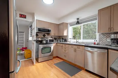 a kitchen with wooden cabinets and stainless steel appliances at Spacious & Modern by the Beach in White Rock