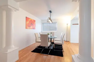 a dining room with a table and white chairs at Spacious & Modern by the Beach in White Rock