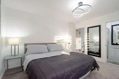 a bedroom with a large bed and a mirror at Spacious & Modern by the Beach in White Rock