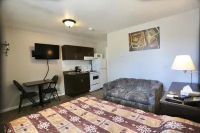 a hotel room with a bed and a couch and a table at Blue Bell Inn in Fort Nelson