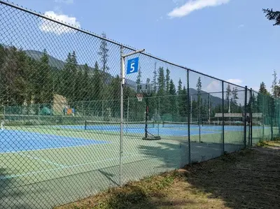 a fence on a tennis court with a ball at The Powder Nook, Hot Pools, Mile 1 Express Chair in Panorama