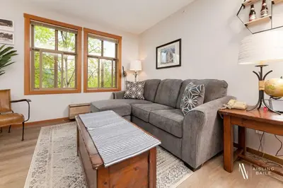a living room with a couch and a table at The Powder Nook, Hot Pools, Mile 1 Express Chair in Panorama