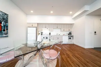 a large white kitchen with a glass table and chairs at Steamy Romantic Greek Corneer Suite King U/G Wifi in Edmonton