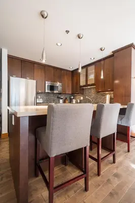 a kitchen with wooden cabinets and a large table with chairs at 2BR in Greyhawk, Hot Tub and Sauna, Gas Fireplace, Secure Parking in Whistler