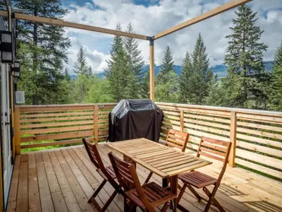 a wooden table and chairs on a wooden deck at Golden Tiny Homes in Golden