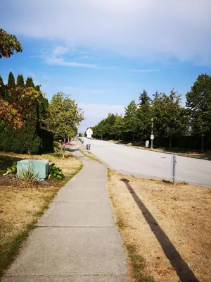 an empty street with a sidewalk next to a road at Jimmy B&B in Surrey