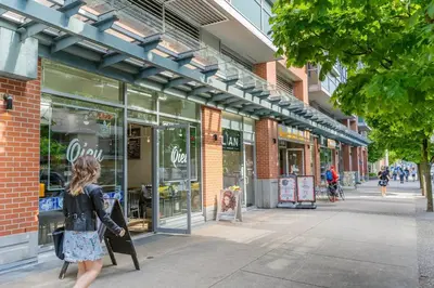 a woman walking down a sidewalk in front of a store at Downtown King Suite-Surround Views-Pool/Gym/Parkng in Vancouver